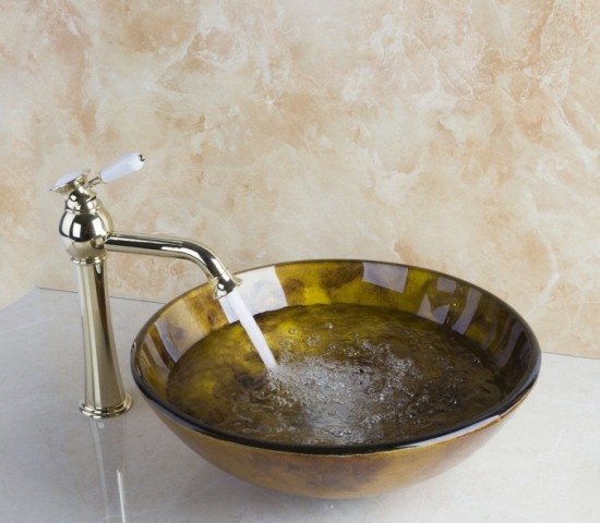 Gouden afgewerkte wastafel kraan met porselein handvat en hand geschilderde goudkleurige glazen waskom